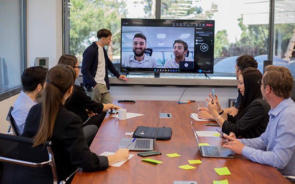 Profesor y 6 alumnos atendiendo a la clase online en pantalla
