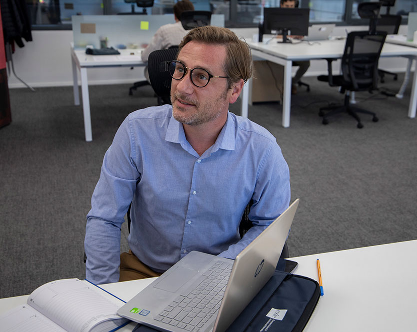 Un profesor de ESIE atiende con un ordenador en la mesa