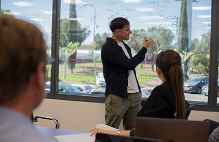 Profesor de ESIE explicando a dos alumnos del master online